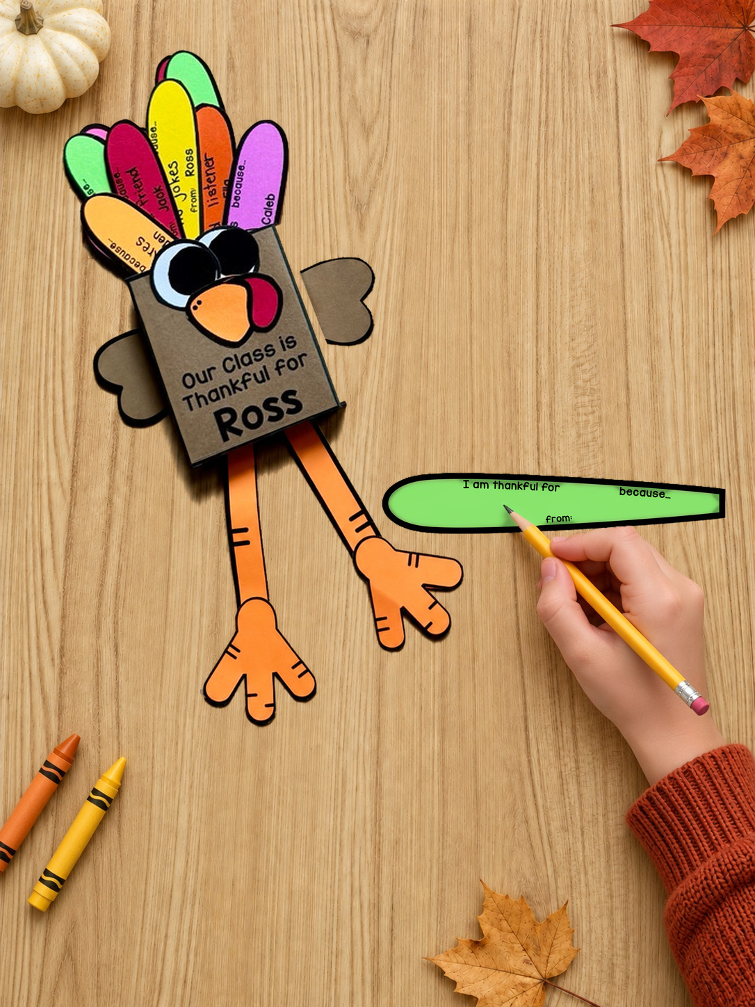 A blank green friendship feather beside a turkey labeled Ross, with a hand holding a pencil.