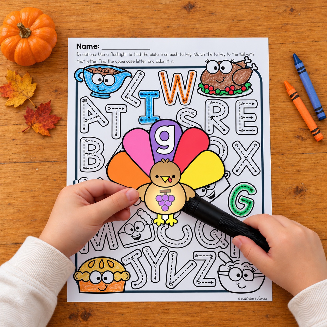 Flashlight reveals grapes on a turkey matched to a lowercase g tail above an uppercase alphabet recording page.